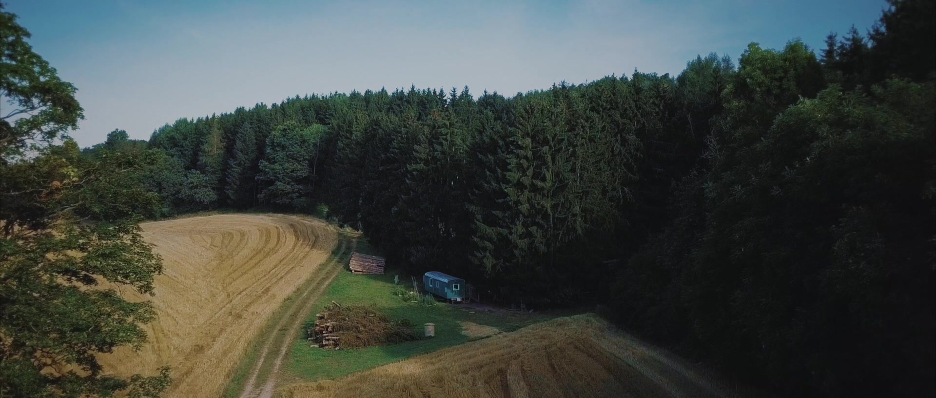 Unser Waldplatz am Waldrand mit Bauwagen und Klohäuschen von oben